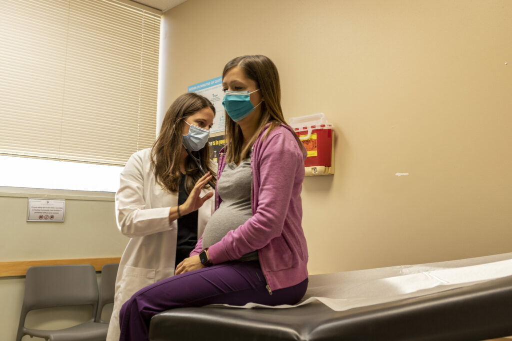 A Hackley Community Care doctor performs a checkup on a pregnant woman in Muskegon, MI.